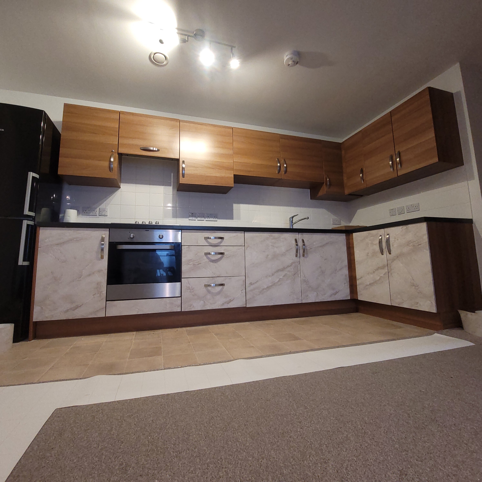 Old wooden kitchen wrapped using a 'marble-effect' architectural film.