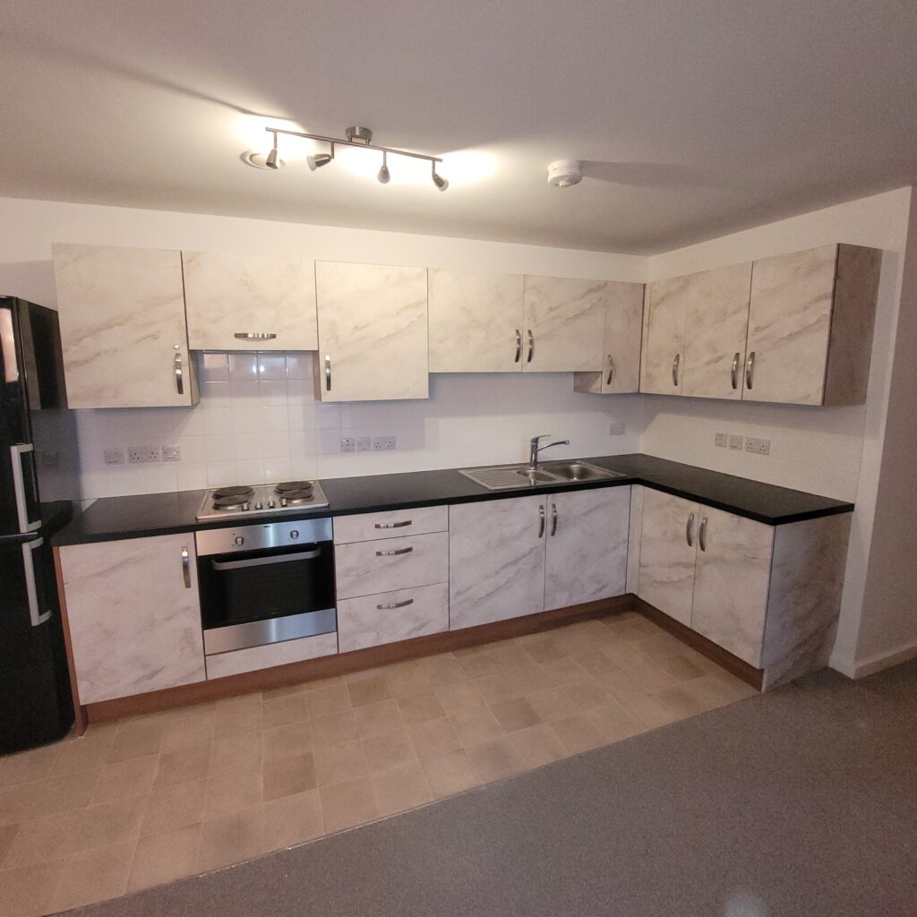 In Woolston (Southampton) we transformed this dated looking 'wood-effect' kitchen by wrapping the doors with a brighter and clean 'marble-effect' vinyl.