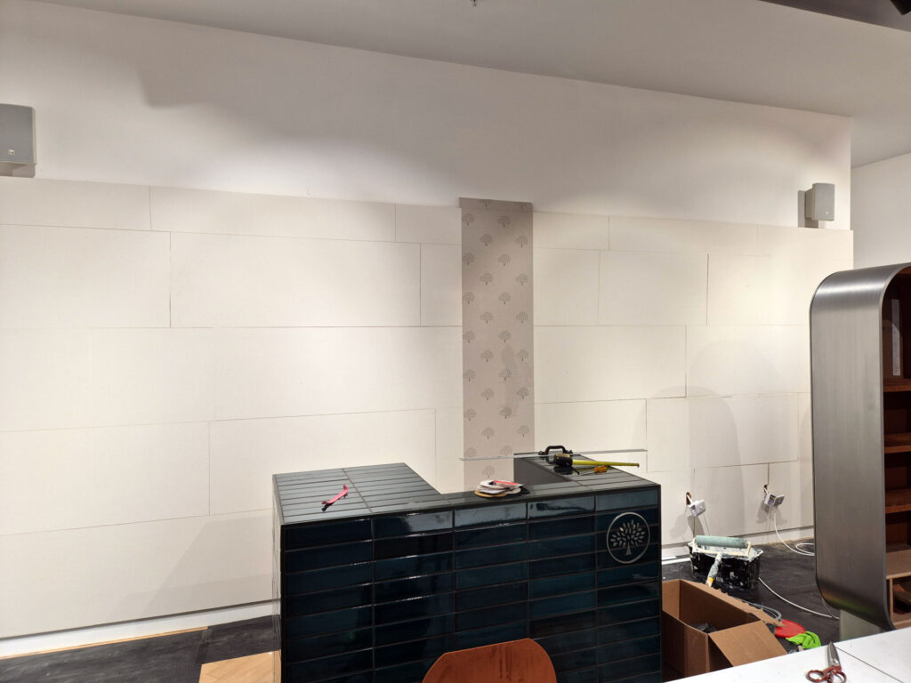shop interior main feature wall wallpaper hanging begins